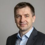 Портрет уверенного российского бизнесмена с дружелюбным взглядом на нейтральном размытом фоне студии